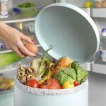 Out of date in garbage bin in front of fridge
