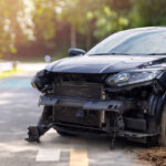 Front of black color car big damaged and broken by accident on city street parking can not drive any more. With copy space for text or design